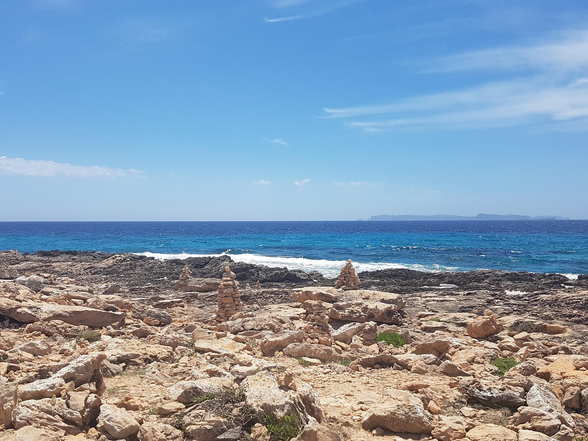 Steintürmchen auf dem Weg zum Strand von Es Caragol