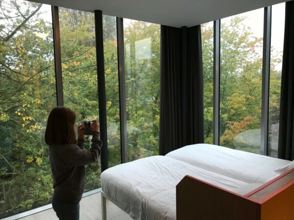 Zimmer im Generator Hotel in Amsterdam mit grossen Fensterscheiben und Blick ins Grüne.