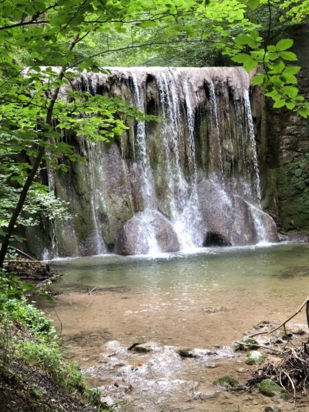 Hoher Wasserfall mitten im Wald in Zürich.