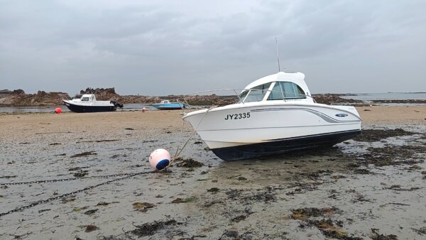 Stillliegendes Boot im Sand vor der Insel Jersey.