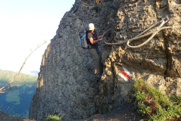 Frau klettert am Seil über Felsvorsprung am Wagenleis.