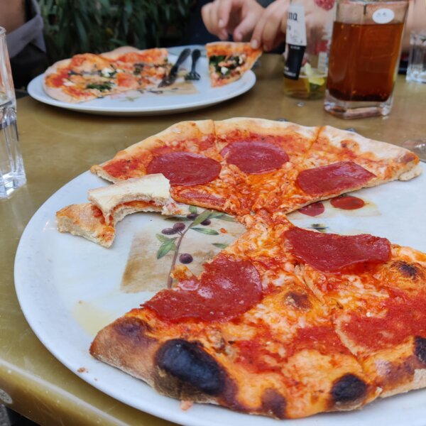 Angefangene halbe Pizza Salami und eine Pizza Spinaci im Hintergrund