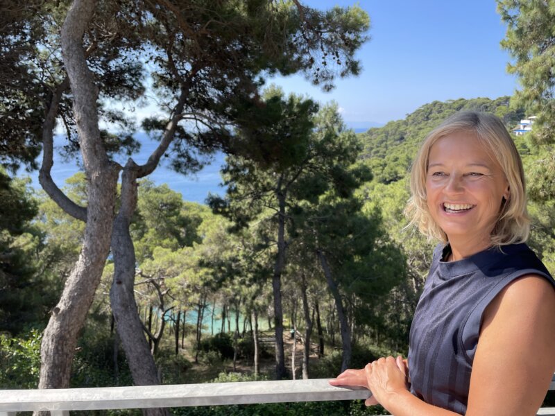 Hotelterrasse mit Liegestühlen und herrlicher Aussicht auf Pinienwälder und das Meer