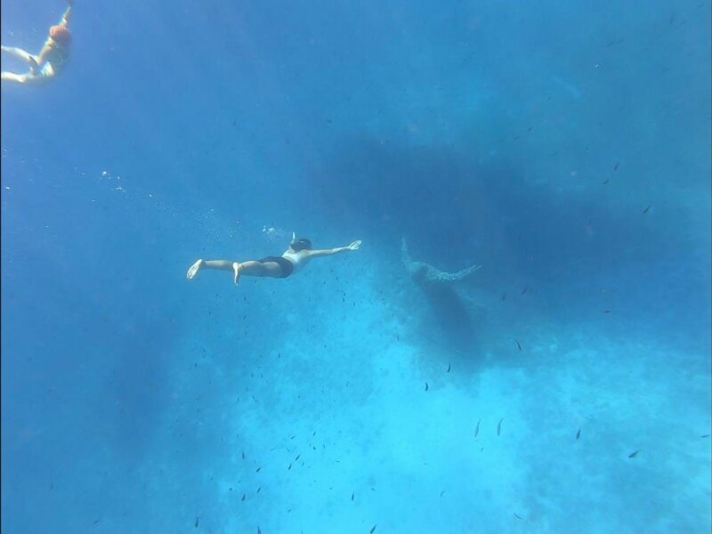 Eine Schwimmerin taucht zur riesigen Statue des Heiligen Padre Pio auf dem Meeresgrund.
