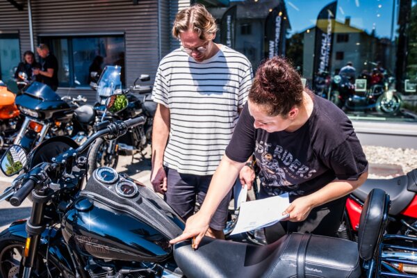 Die BMW R 18 mit der ich die nächsten Tage über die Pässe kurven sollte. Eine Mitarbeiterin von Motorcycle Heaven erklärt einem Teilnehmer der Motorradreise seine Harley Davidson.