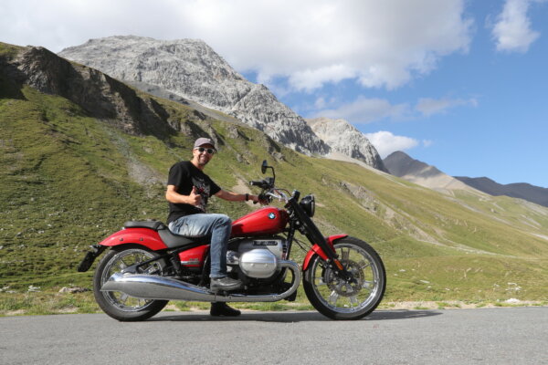 Motorradfahren am Maloja-Pass verlangt einiges an Fahrkönnen für die engen Kurven. Posieren für die Kamera mit einem grossen Grinsen im Gesicht.