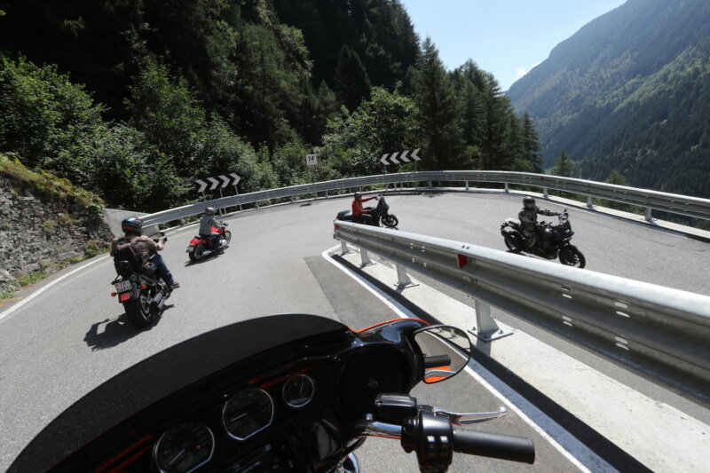 Mit den Motorrädern über die Landstrassen in Graubünden bei Schmitten. In der Motorrad-Gruppe hintereinander den Splügen-Pass hinunter. Passtafel auf dem Stelvio (Stilfser Joch). Biker auf einer Harley Davidson bei Davos.