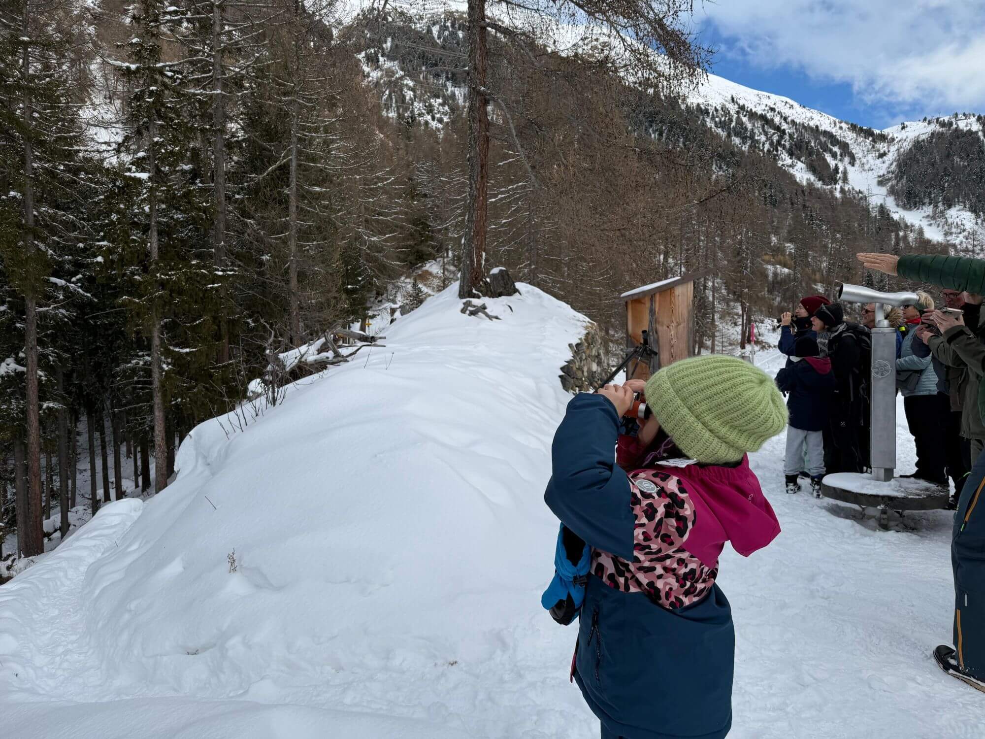 Mina mit einem Fernglas bei der Steinbock-Safari in Pontresina