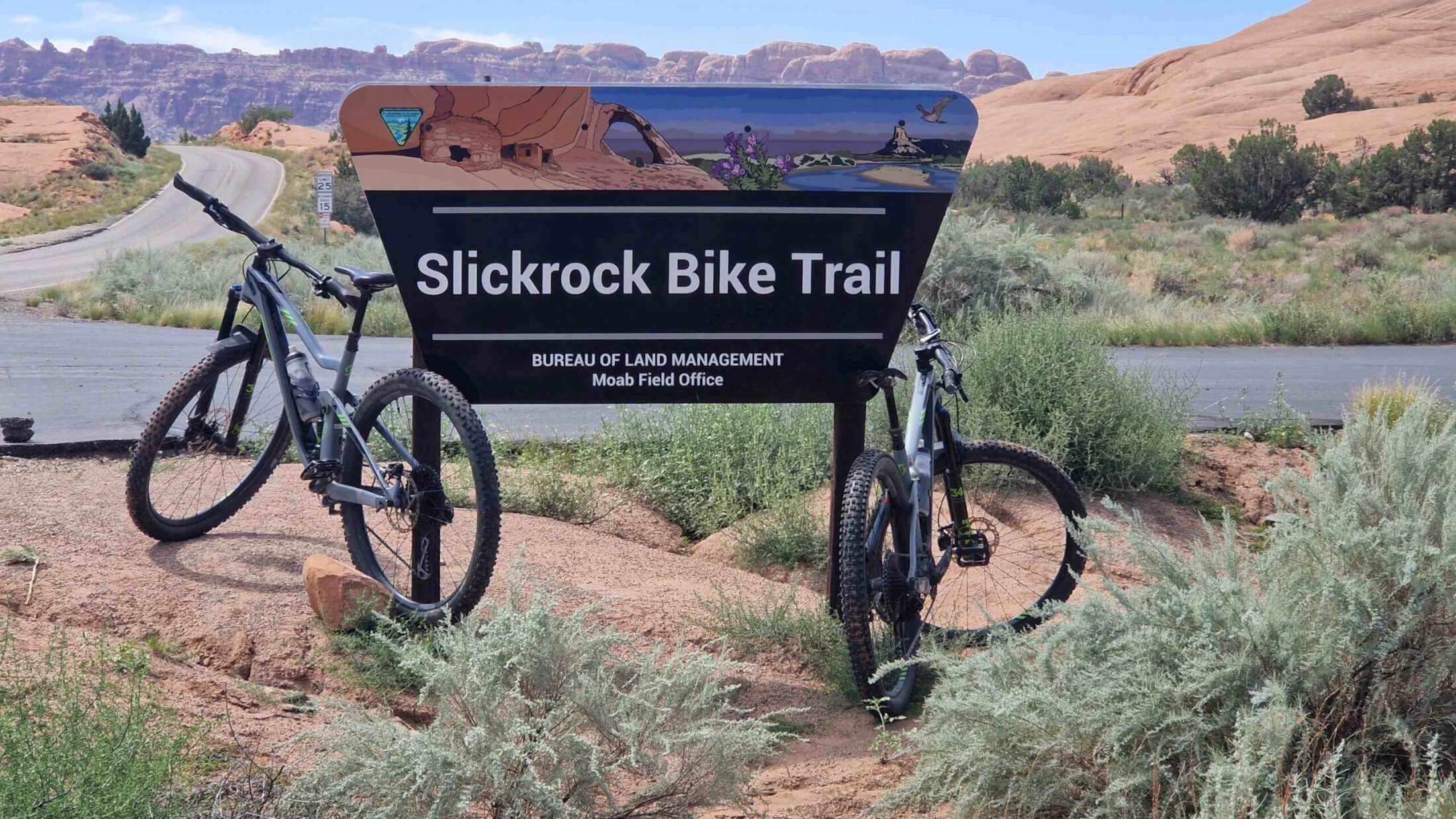 Zwei Mountainbikes lehnen am Eingangsschild des Slickrock Bike Trails
