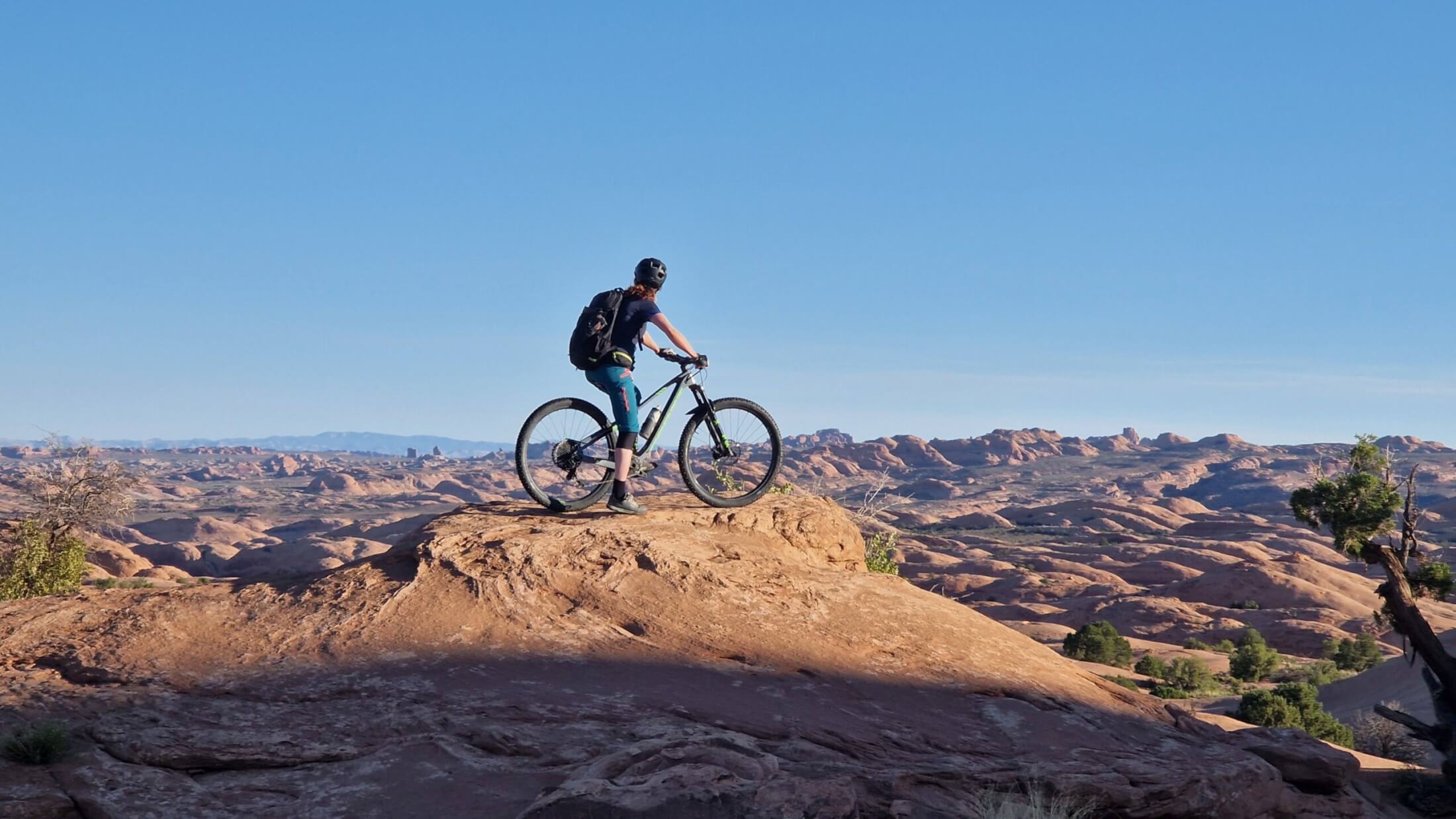 Mountainbikerin lässt ihren Blick über die Sandsteinwürste von Moab schweifen