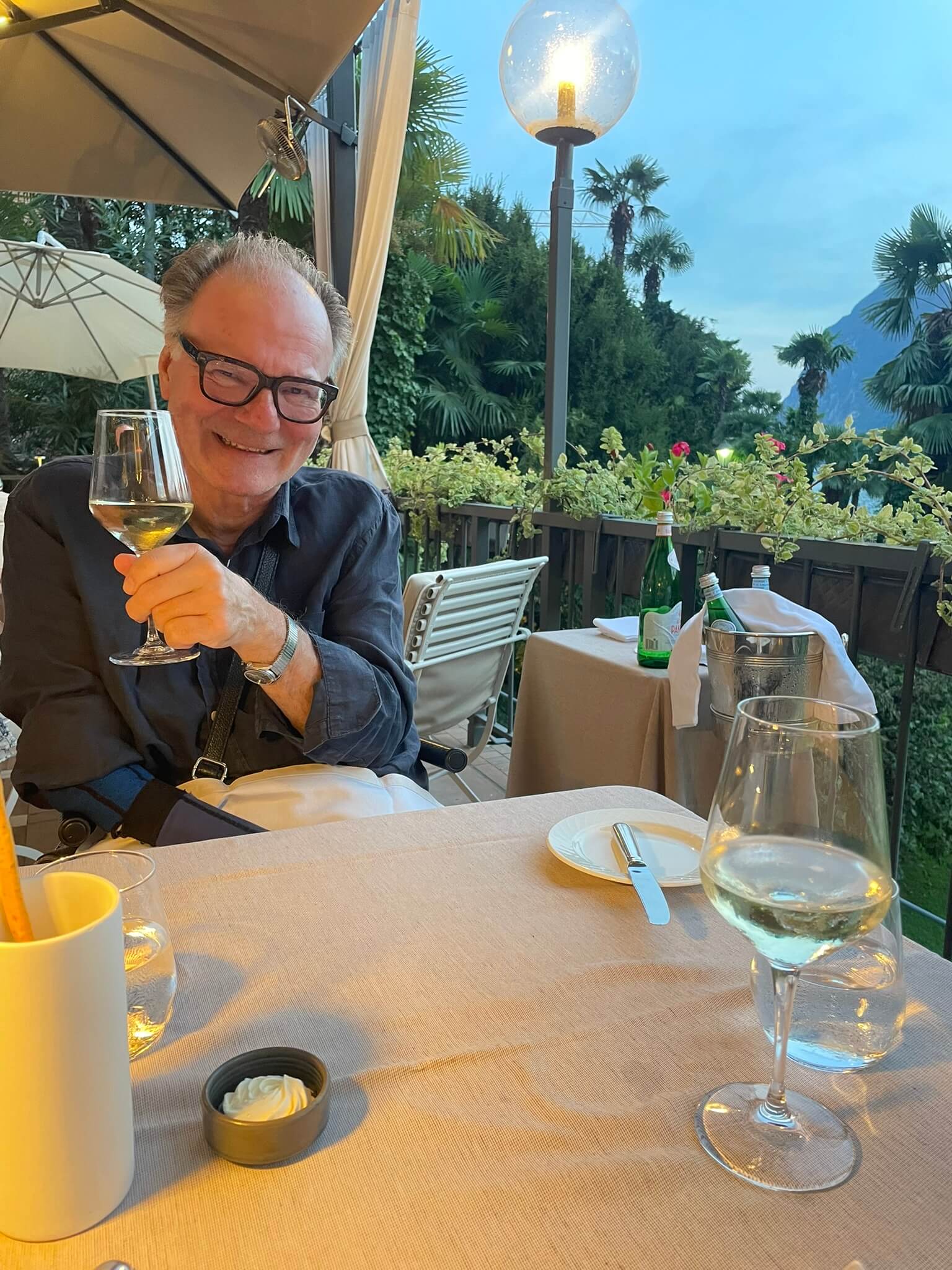 Alex mit Weinglas beim Abendessen auf der Terrasse des Restaurants Le Relais