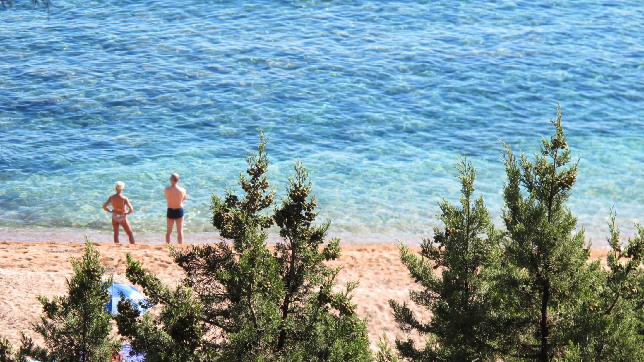 türkises Meer und zwei Menschen am Strand Cala Gonone