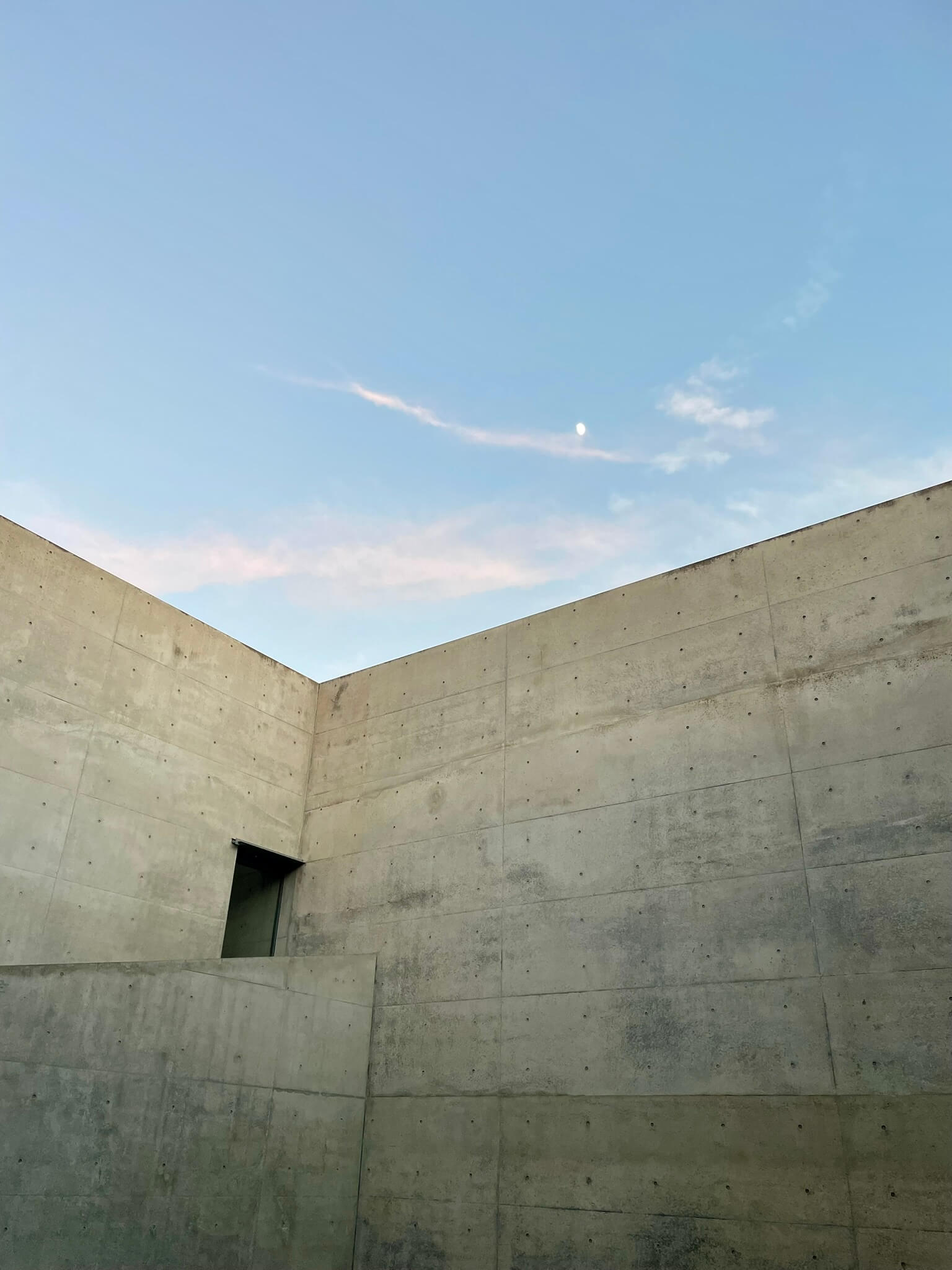 Chichu Art Museum: graue Betonwand und blauer Himmel mit rosa Streifen