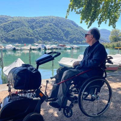 Alex Oberholzer mit Gepäck vor Booten im Luganersee